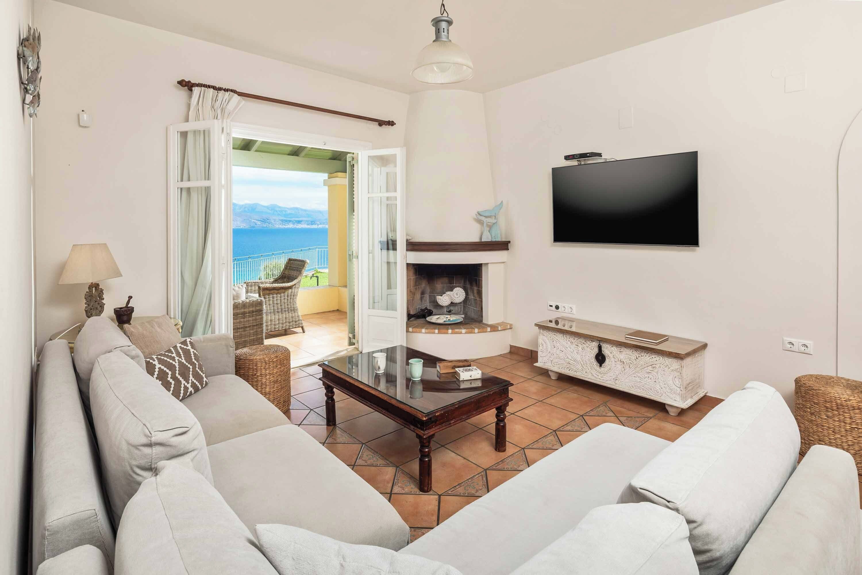 A living room with a sofa, a coffee table, a fireplace, and a TV.