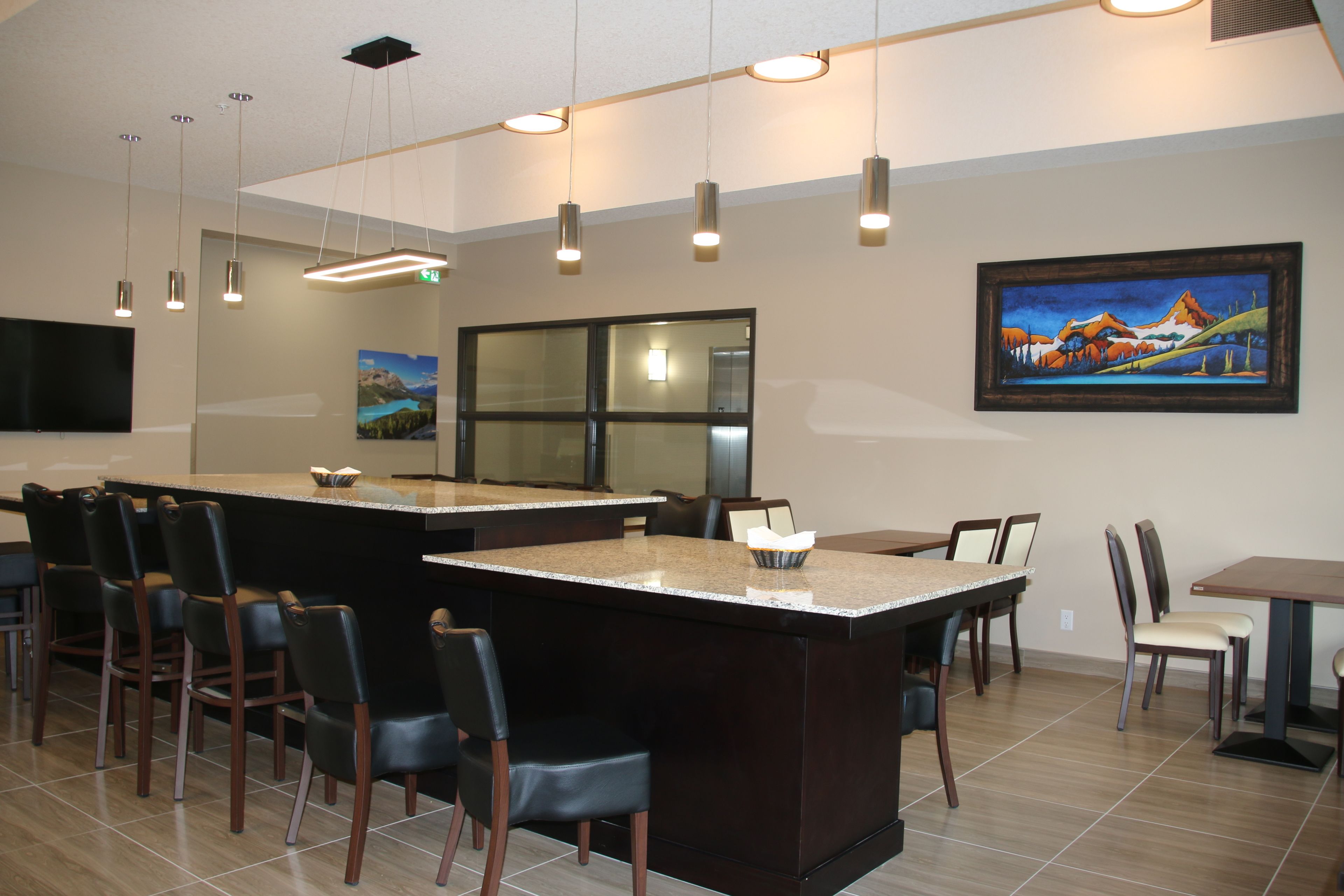 A modern restaurant with a bar area, high chairs, and a large window.