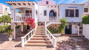 A white building with a stone facade, a staircase leading to a balcony, and a door with a star decoration. - Villa Mascaro - Six Bedroom Villa, Sleeps 12 (Serpentona)