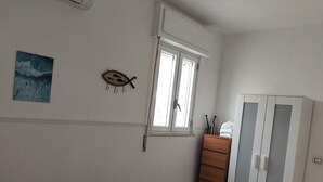 A room with a bed, a wardrobe, a window, and a wall-mounted fish decoration. - BEACH HOUSE EACH CIR NO.19089017C203908 (Ognina)