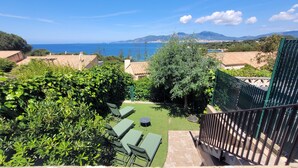 A terrace with a view of the sea, surrounded by greenery and a metal fence. - Terraced house with 3 bedrooms and garden, only 100m. from the beach (Grosseto-Prugna)