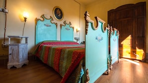 A bedroom with a wooden bed, a nightstand, a dresser, and a wall-mounted lamp. - Appartamento Bell - 2, 4 persone (Sansepolcro)