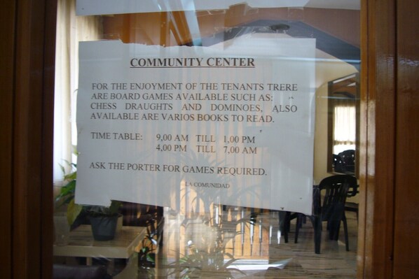 A sign in a window advertising board games and books available at the community center. - COBLANCA 3 (2 BEDROOMS) (Benidorm)