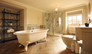 A bathroom with a freestanding bathtub, a glass-enclosed shower, a toilet, and a radiator. - The Merchant's House (Eyemouth)