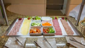 A buffet with various food items and utensils.
