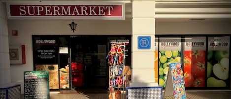 Een supermarkt met een 'HOLLYWOOD'-bord, een 'SUPERMARKET'-bord en een 'HOLLYWOOD supermarkt'-bord.