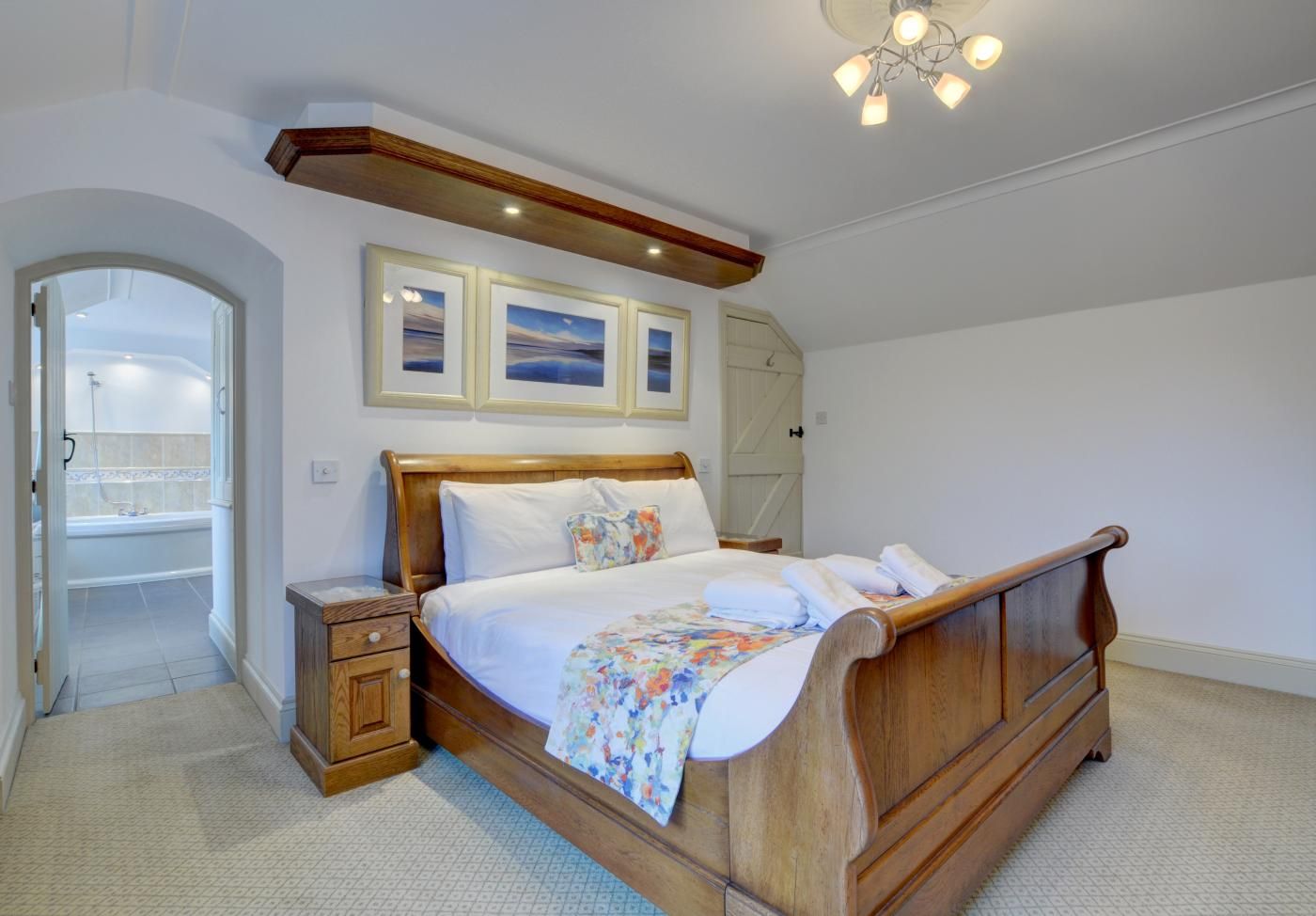 Ein Schlafzimmer mit einem Holzbett, einem Nachttisch, einem Einbauschrank und einem Duschbereich.