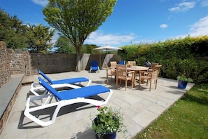 A patio with lounge chairs, a table, and chairs. - 4 Bed in Braunton (oc-anchor) (Croyde)