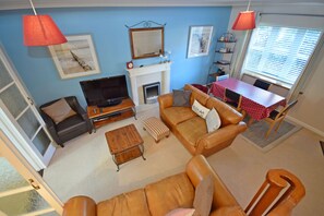 Una sala de estar con chimenea, una mesa de comedor y un televisor.