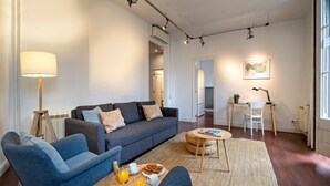 Una sala de estar moderna con un sofá, sillas, una mesa de centro y una lámpara.