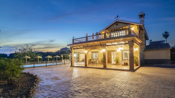 A two-story house with a balcony, a pool, and a paved patio area. - Cubo's Villa Los Javieles / pool / air conditioning / ideal for children / free Wi-Fi (Alhaurín el Grande)