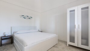 Un dormitorio con cama, mesita de noche, lámpara de pared y armario.