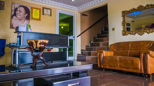 A living room with a sofa, a coffee table, and a staircase.