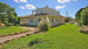 A two-story house with a tiled roof, a well-maintained lawn, and a stone pathway leading to the entrance. - Villa Cora - Javea, Costa Blanca (Javea)