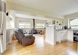 Relax by the fireplace in this cozy living area with a comfortable sofa and adjacent kitchen.