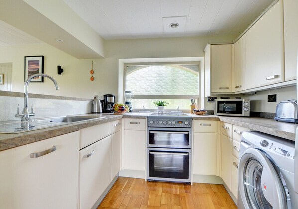 Enjoy cooking in this well-equipped kitchen with a central island, oven, microwave, and toaster.
