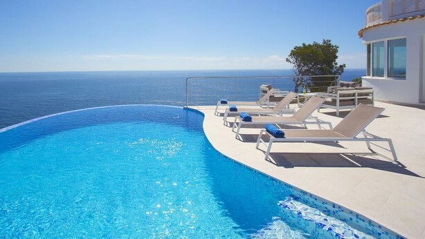 A clear blue infinity pool with lounge chairs and a view of the sea. - Modern and luxury holiday house in Javea, Costa Blanca, Spain  with private pool for 8 persons (Javea)