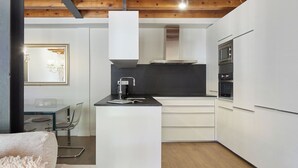 A compact kitchen with white cabinets, a black countertop, and stainless steel appliances. - Val Arties 3 by FeelFree Rentals (Arties)
