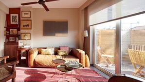 A cozy living room with a sofa, coffee table, and chairs, a ceiling fan, and a large window offering a view of the outside. - Gaindegi by FeelFree Rentals (San Sebastián)