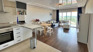 Een moderne keuken met een eethoek, een bank en uitzicht op het omliggende landschap.