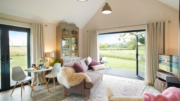 A spacious living room with a large window, a sofa, a television, and a dining area. - Broomers Barn, Richards Castle, Ludlow , Shropshire (Ludlow)