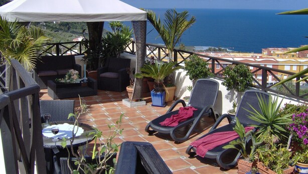A terrace with outdoor furniture, a white canopy, and potted plants. - Rustic holiday home with small patio-terrace (Icod de los Vinos)