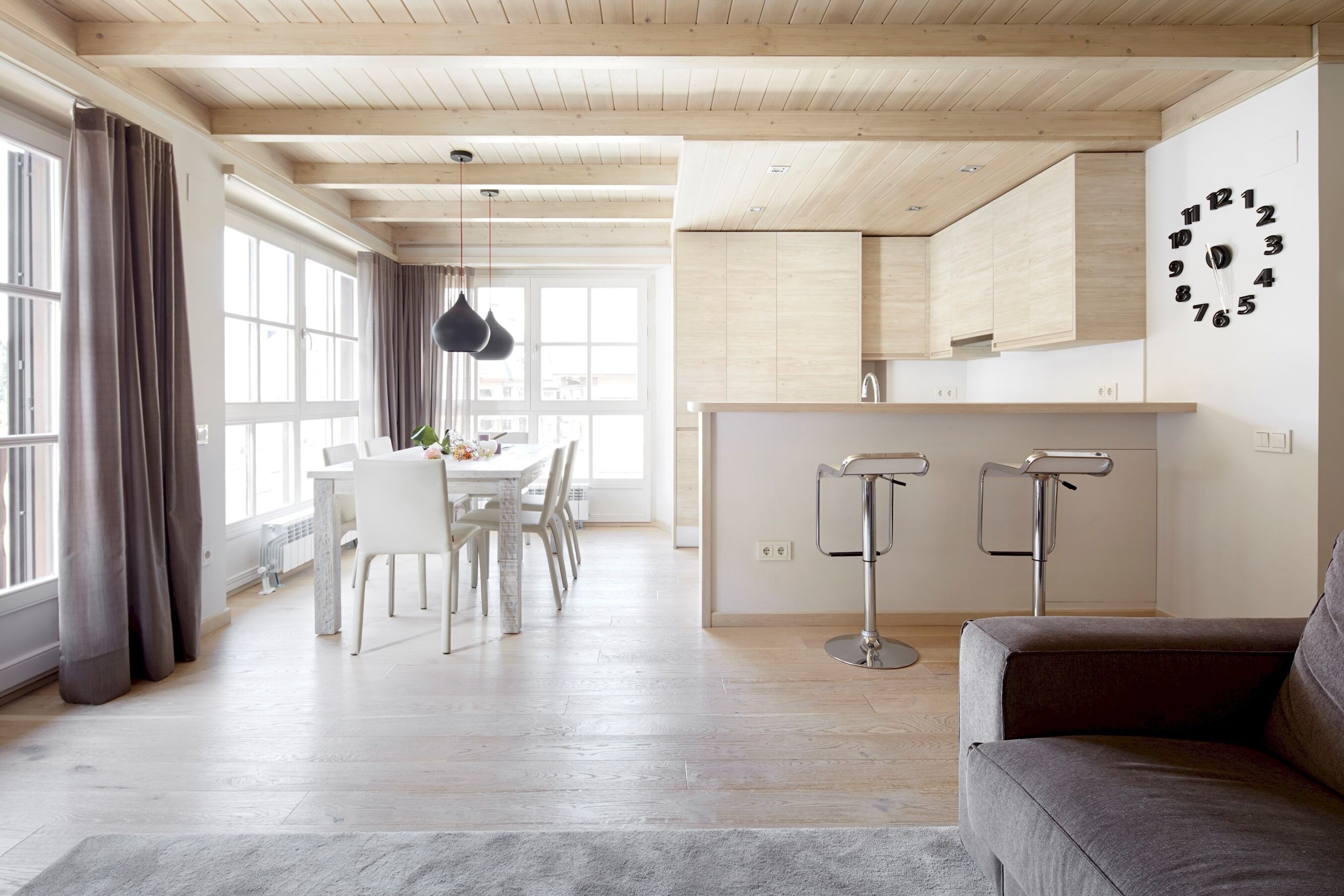 Une cuisine moderne avec des meubles en bois, un plan de travail blanc et une horloge murale.