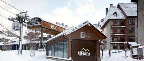A snow-covered building with a sign reading "P-3" and "PIETA VALRUDA parking private."