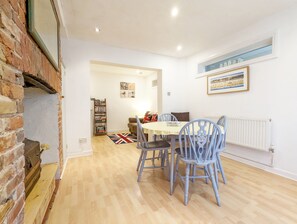 Un coin repas avec une table et des chaises, une bibliothèque et un tableau encadré au mur.