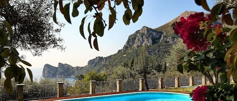 A swimming pool with lounge chairs and a view of mountains.