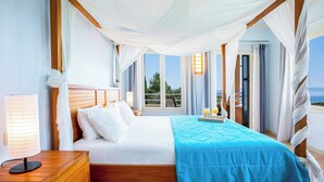 A bedroom with a bed, a bedside table, a lamp, and a view of the outdoors. - Villa Agapi - Four Bedroom Villa, Sleeps 8 (Lefkada)
