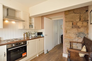 A kitchen with white cabinets, a microwave, and an oven.