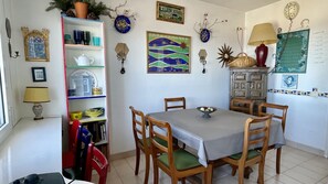 Un espace repas comprenant une table, des chaises et une bibliothèque.