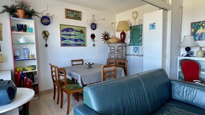 Ein Essbereich mit Tisch, Stühlen und einem blauen Sofa.