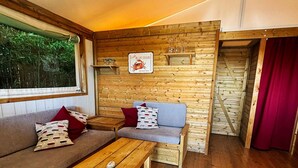 A cozy cabin interior with a wooden floor, a sofa, a table, and a sign indicating fresh blue crabs are served. - A 2 bedroom luxury lodge with heated covered pool (Henansal)