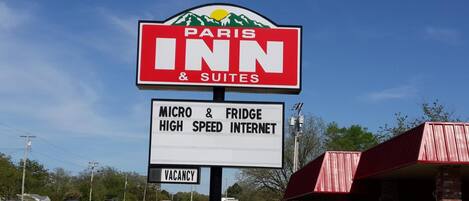 Une enseigne « Paris Inn & Suites » avec un motif de montagne, indiquant l’emplacement de l’établissement.