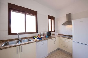 A compact kitchen with a dishwasher, a microwave, and a refrigerator.