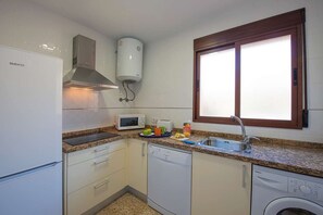 A compact kitchen with a built-in microwave, a sink, and a dishwasher. - Villa Ambar - Plus (Calpe)
