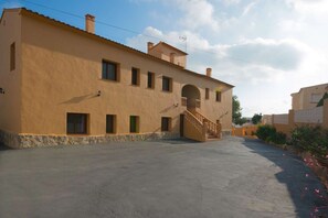 A building with a flat facade, multiple windows, and a central staircase leading to an upper level. - Villa Ambar - Plus (Calpe)