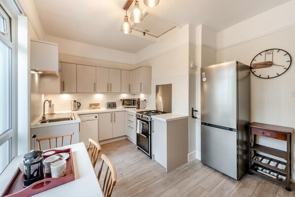 Mikrobølgeovn, ovn, oppvaskmaskin og høy barnestol