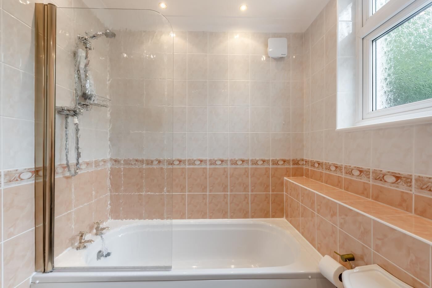 A bathroom with a bathtub, a shower, and a window.