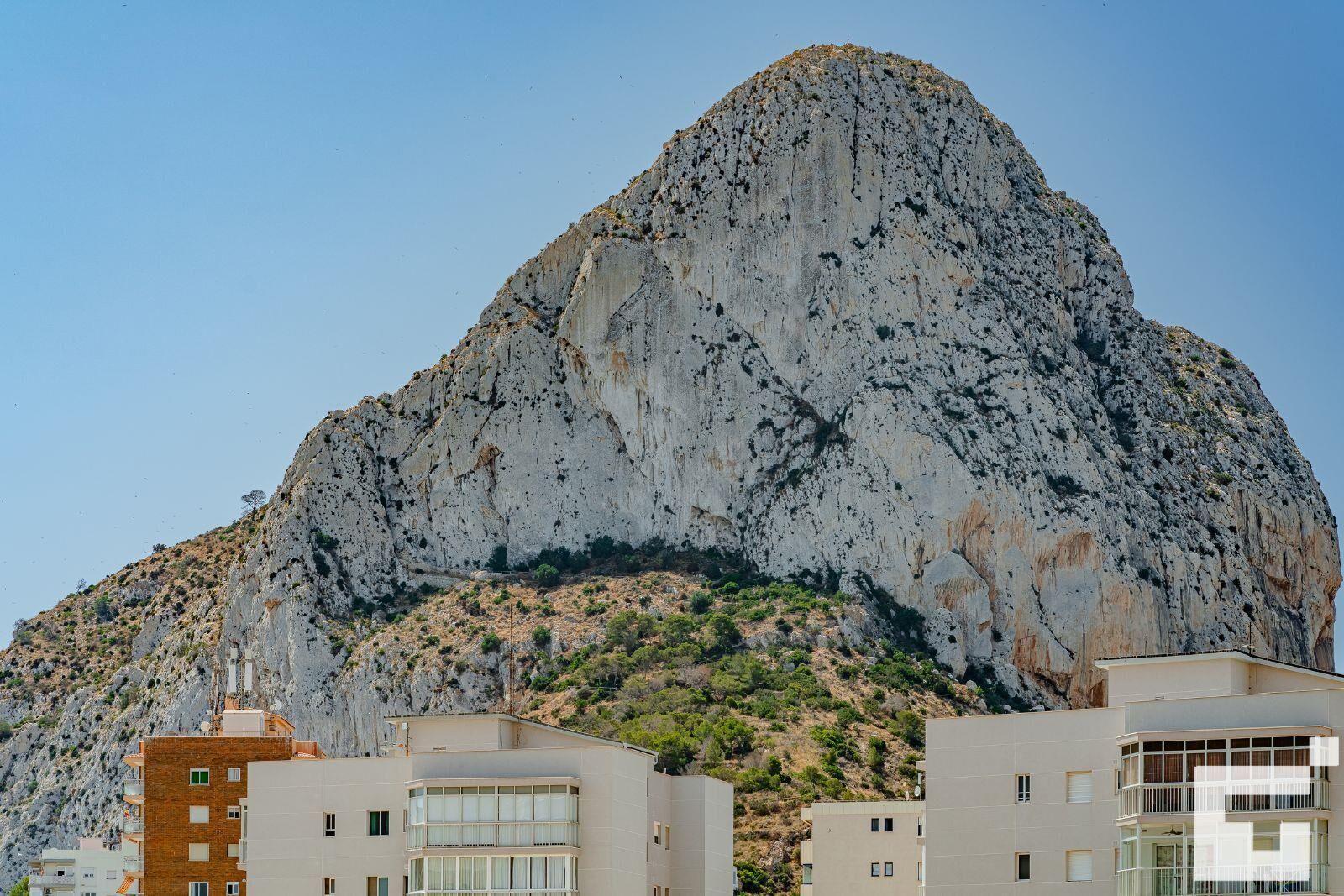 A mountain with a rocky surface and sparse vegetation.