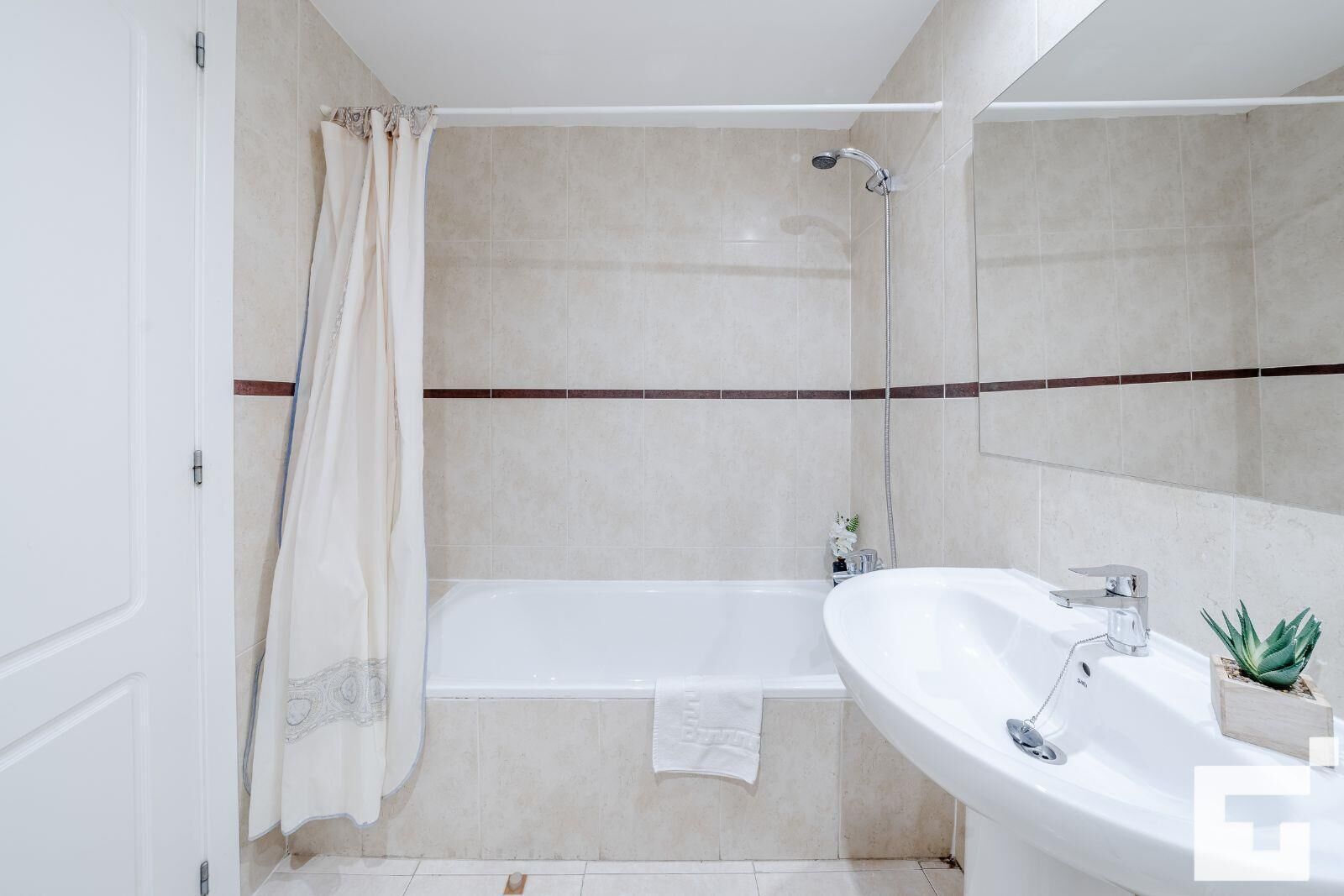 A bathroom with a bathtub, a shower, and a sink.