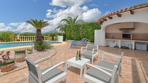A patio area with outdoor seating, a pool, and a barbecue area. - Large and comfortable villa  with private pool in Javea, on the Costa Blanca, Spain for 8 persons (Javea)