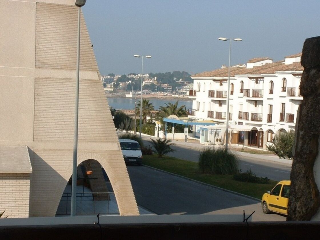 Blick auf die Küste mit einem Gebäude, das ein großes Portal und eine Straße mit einem gelben Auto zeigt.