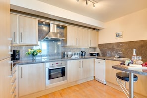 A modern kitchen with stainless steel appliances, a built-in oven, and a dishwasher.