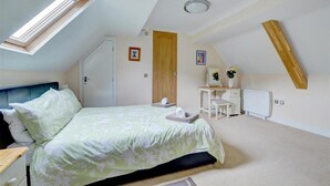 Ein Schlafzimmer mit Bett, Schreibtisch, Stuhl, Heizkörper und Tür.