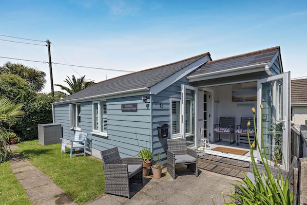 A small, single-story house with a patio area, outdoor furniture, and a garden. - 3 Bed in Croyde (oc-bendal) (Croyde)