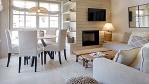 A modern living room with a dining area, wooden floors, and a fireplace. - Val de Ruda Luxe 51 by FeelFree Rentals (Baqueira)
