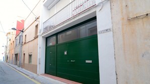 Un edificio con un'anta di garage verde, una facciata bianca e un cartello con la scritta "LA TIMPA".